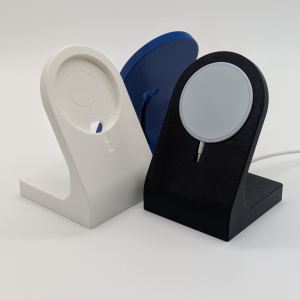 three 3d printed phone charging stands in white, blue, and black